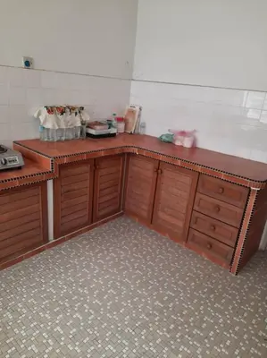 a kitchen with wooden cabinets and a counter top at Rumah Teres Teluk Kumbar in Bayan Lepas