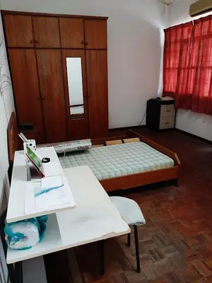 a room with a bed and a table with a desk at Rumah Teres Teluk Kumbar in Bayan Lepas
