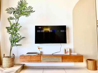 a flat screen tv on a wall in a living room at Urban Suites Jelutong #Highfloor Seaview #Water dispenser #Infinity Pool #5pax #3BR2bath #2Queen1Single #Quality well maintained #Private host in Jelutong