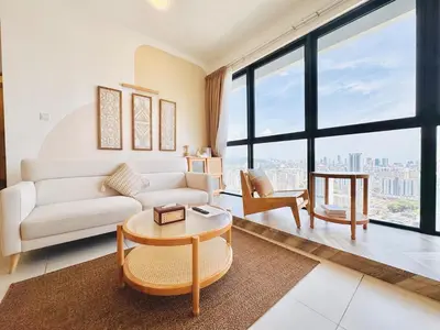 a living room with a couch and a table at Urban Suites Jelutong #Highfloor Seaview #Water dispenser #Infinity Pool #5pax #3BR2bath #2Queen1Single #Quality well maintained #Private host in Jelutong