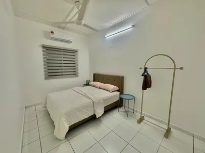 a white bedroom with a bed and a blue stool at Urban Eats Stay in Ipoh