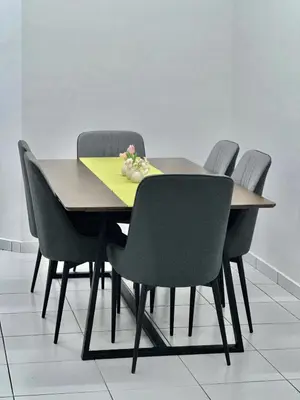 a table with four chairs and a yellow napkin on it at Urban Eats Stay in Ipoh