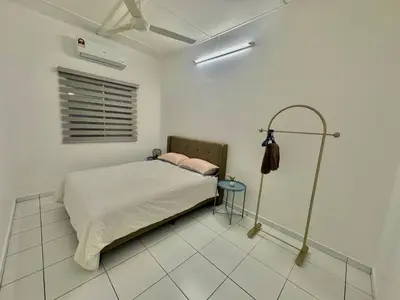a bedroom with a bed in a white room at Urban Eats Stay in Ipoh
