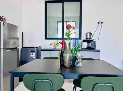 a kitchen with a table with a vase of flowers on it at Familystay Home 3BR-10PAX Urban suites in George Town