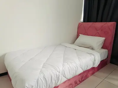 a bed in a room with a pink headboard at Familystay Home 3BR-10PAX Urban suites in George Town
