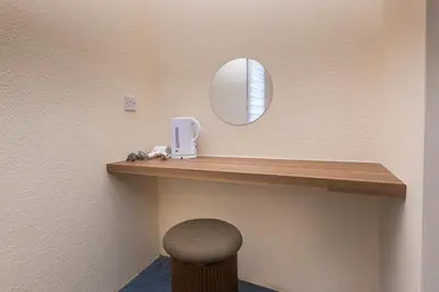 a vanity with a mirror and a stool in a room at Bahari 58 in George Town