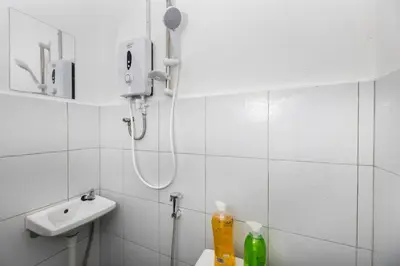 a white bathroom with a shower and a sink at Bahari 58 in George Town