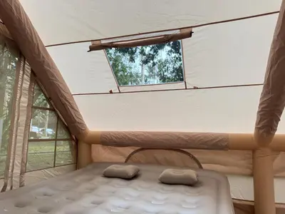 a bed in a room with a window at Glamping in Tapah