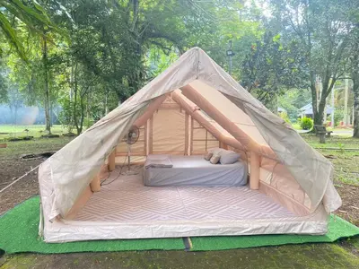 a bed in a canvas tent in a park at Glamping in Tapah