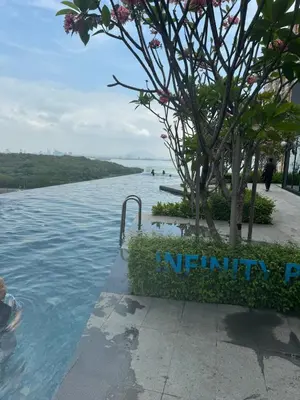 a swimming pool with a tree in the water at newly renovation apartment 3BR pool 10 pax in George Town