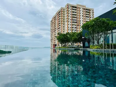 a building is reflected in a pool of water at Georgetown Komtar Familystay 3BR 10Pax in George Town