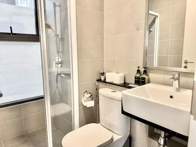 a bathroom with a toilet and a sink and a shower at Tropicana 218 Macalister #Charm #InfinityPool #WideSeaview #6pax #3BR2bath #1King2Queen #Quality well maintained #Private host in George Town