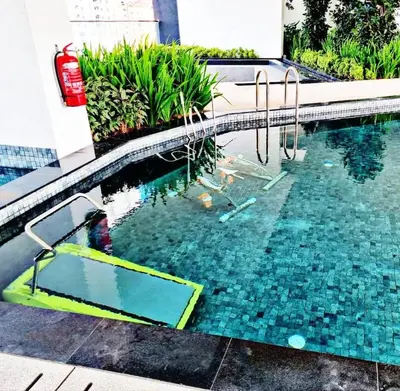 a swimming pool with a diving board in the water at Comfort Stay Family Home 3BR 10PAX in George Town