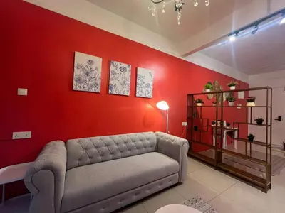 a living room with a couch and a red wall at RedHouse Sky Garden Klabang 10 pax in Chemor