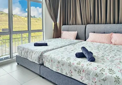 two beds in a bedroom with two blue pillows on them at TheFloral Penthouse Night Market Wifi & Netflix in Brinchang