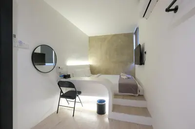 a room with a bed and a chair and a mirror at Loft 82 in Bukit Mertajam