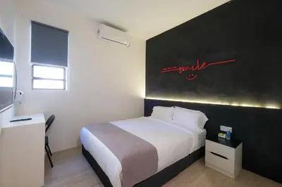 a bedroom with a white bed and a black wall at Loft 82 in Bukit Mertajam