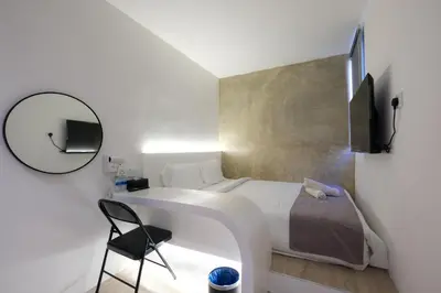 a bedroom with a bed and a chair and a mirror at Loft 82 in Bukit Mertajam