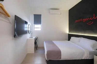 a hotel room with a bed and a tv at Loft 82 in Bukit Mertajam