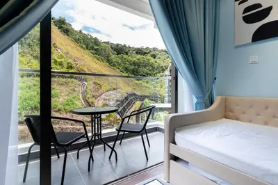 a room with a bed and a table and chairs at Royo Homestay in Palas Horizon in Brinchang