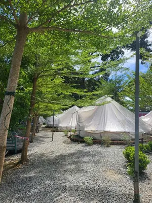 a large white tent in a field with trees at Tok Mat Village & Adventure Park in Kampong Kepayang