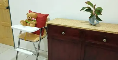 a teddy bear sitting on a chair next to a counter at Aloe Vera Homestay - 3 Bed Rooms Corner House in Kamunting