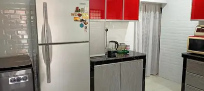 a kitchen with red cabinets and a refrigerator at Aloe Vera Homestay - 3 Bed Rooms Corner House in Kamunting