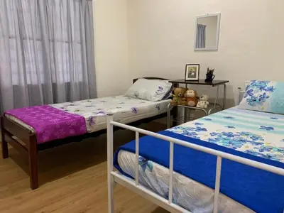 a bedroom with two beds and a window at Aloe Vera Homestay - 3 Bed Rooms Corner House in Kamunting