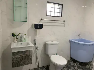a white bathroom with a toilet and a sink at Aloe Vera Homestay - 3 Bed Rooms Corner House in Kamunting