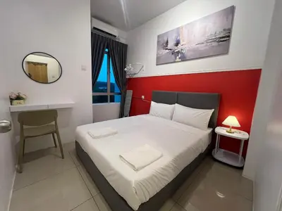 a small bedroom with a bed with a red wall at RedHouse Sky Garden Klabang in Ipoh