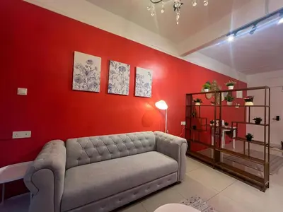 a living room with a couch and a red wall at RedHouse Sky Garden Klabang in Ipoh