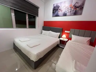 a bedroom with two beds and a red wall at RedHouse Sky Garden Klabang in Ipoh
