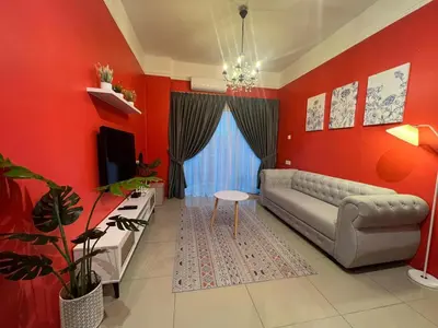 a living room with red walls and a couch and a table at RedHouse Sky Garden Klabang in Ipoh