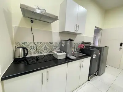 a kitchen with white cabinets and a black counter top at The Anderson Ipoh Town in Ipoh