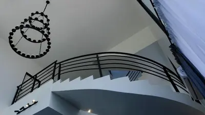 a spiral staircase with a chandelier hanging from the ceiling at Khoo Family Villa in Ipoh