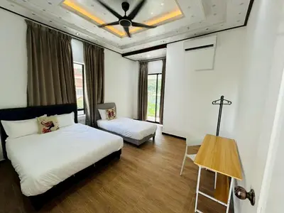 a bedroom with two beds and a ceiling fan at Khoo Family Villa in Ipoh