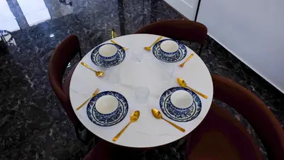 a table with four cups and saucers on it at Khoo Family Villa in Ipoh