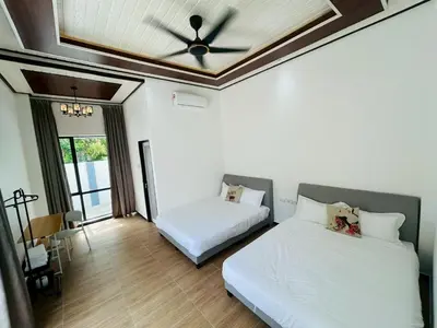 a bedroom with two beds and a ceiling fan at Khoo Family Villa in Ipoh