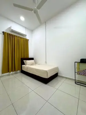 a bedroom with a bed with a yellow curtain at Haneya Homestay in Kampong Banggol Pasir