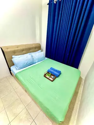 a bed with a blue curtain and a tray of food on it at Lapang Tuju Private Pool Homestay in Sungai Petani
