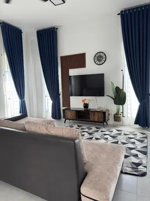 a living room with a couch and a flat screen tv at Lapang Tuju Private Pool Homestay in Sungai Petani