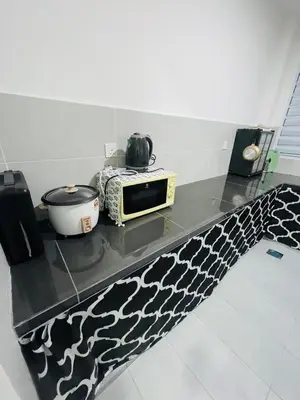 a kitchen counter with a microwave on top of it at Gaya's Homestay Sri Klebang in Ipoh