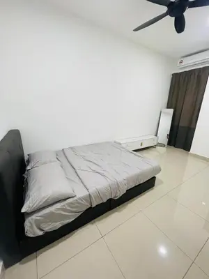 a bed in a room with a ceiling fan at Gaya's Homestay Sri Klebang in Ipoh