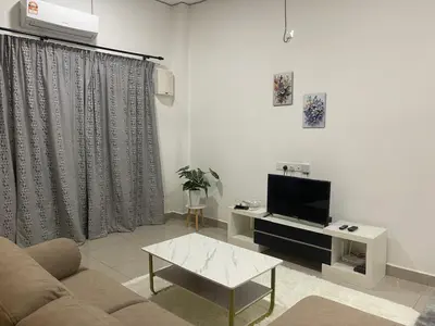 a living room with a couch and a tv at Gaya's Homestay Sri Klebang in Ipoh