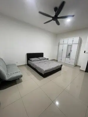 a bedroom with a bed and a ceiling fan at Gaya's Homestay Sri Klebang in Ipoh