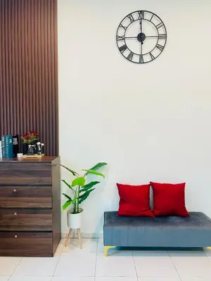 a room with a couch and a clock on a wall at Cozy Home Aman Selesa Netflix Wifi Usm in Parit Buntar