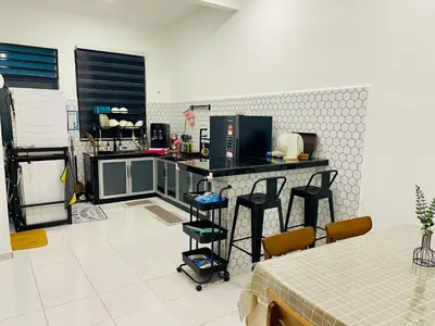 a kitchen with a counter and some chairs in it at Cozy Home Aman Selesa Netflix Wifi Usm in Parit Buntar