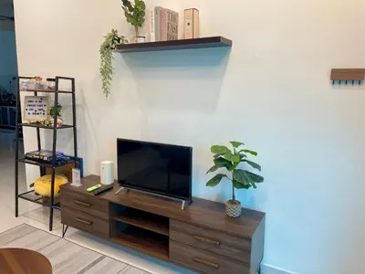 a living room with a flat screen tv on a wooden entertainment center at Cozy Home Aman Selesa Netflix Wifi Usm in Parit Buntar