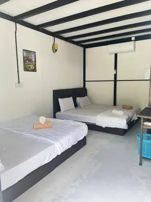 two beds in a room with white walls at Belibis Yard in Kampar