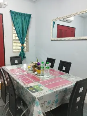 a table with chairs and a table cloth on it at Inap Desa Jalan Baru in Kampong Sedim Number Two